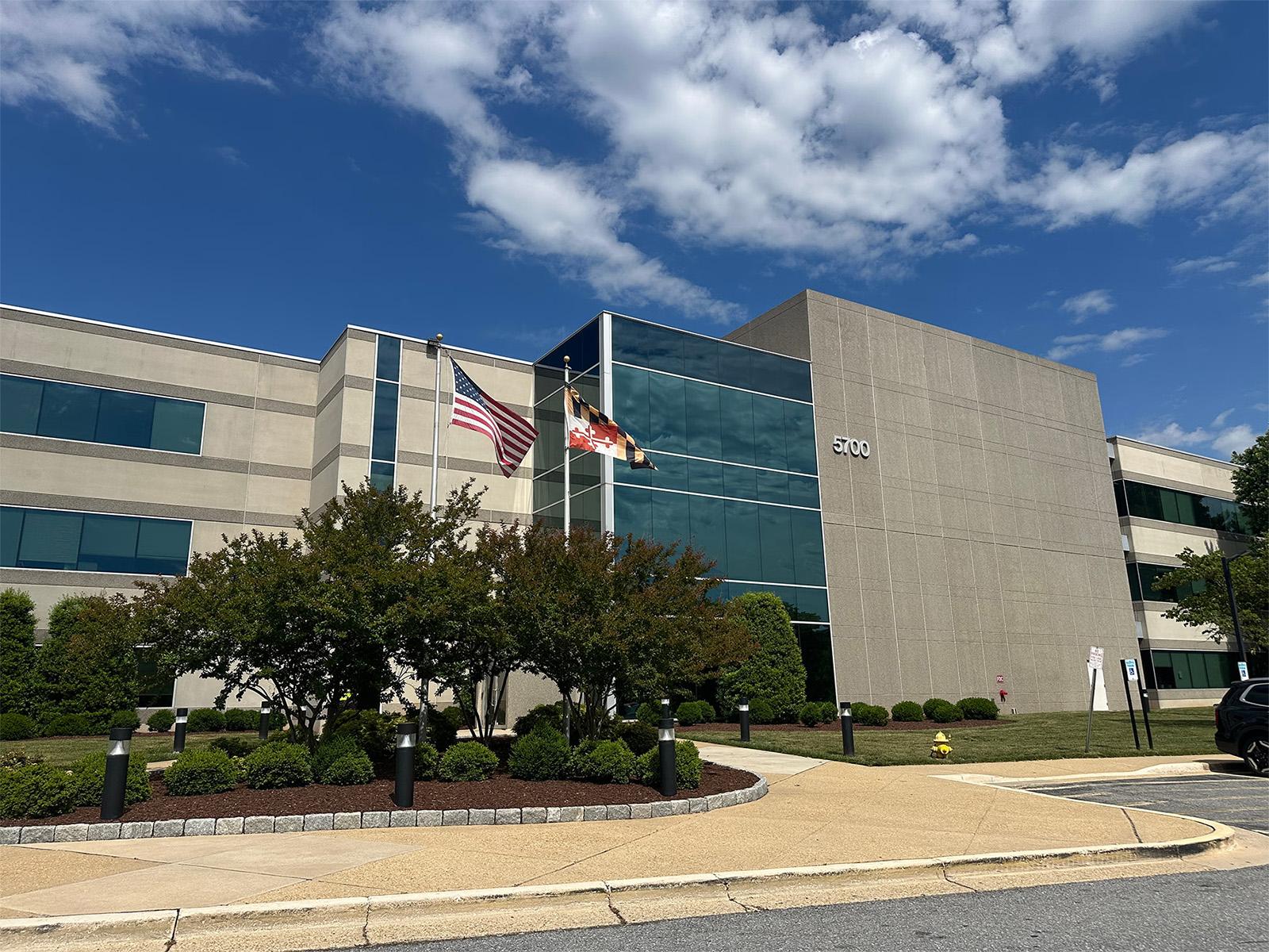 Front of 5700 Rivertech Court against a blue sky with white clouds.